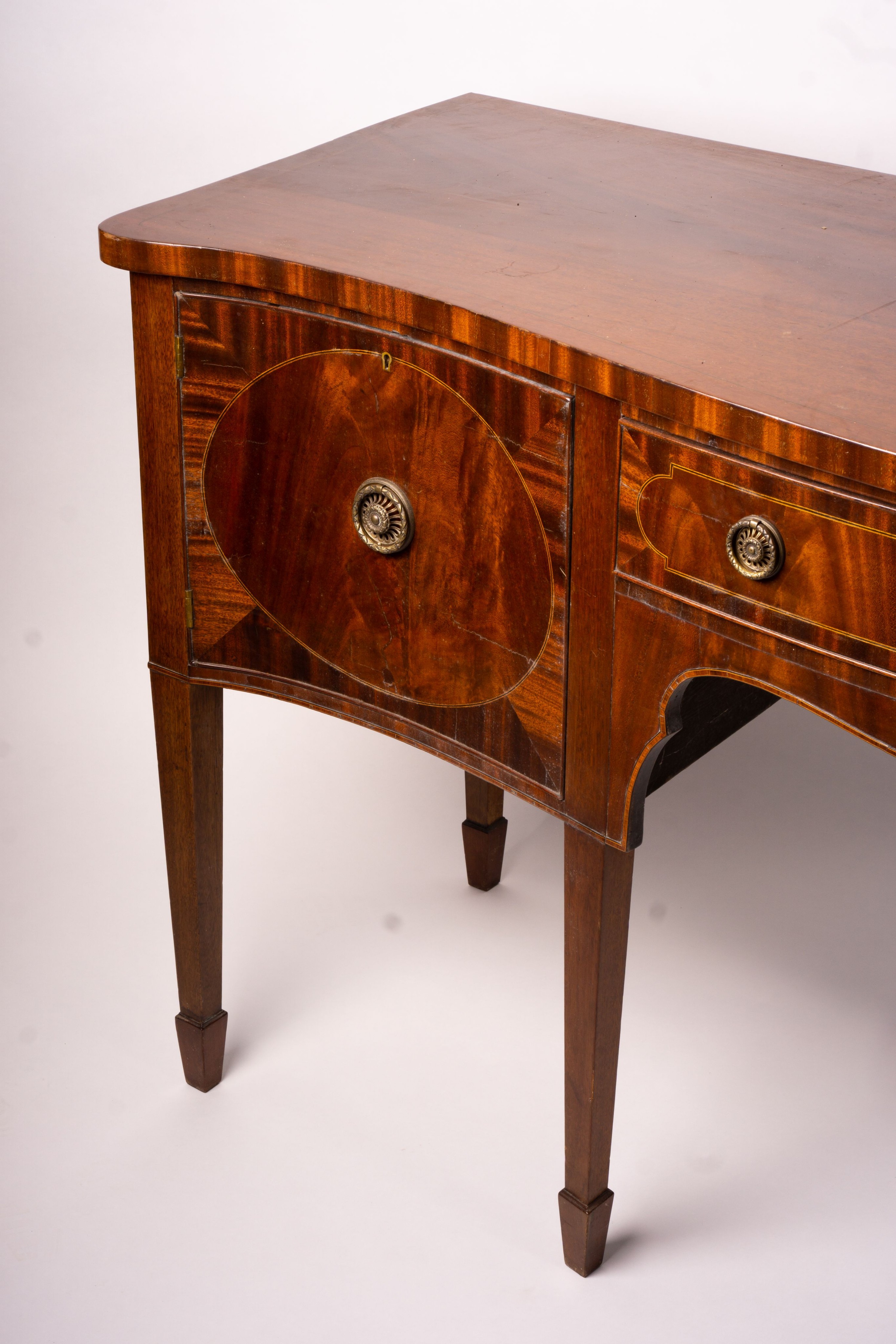 A George III style mahogany serpentine sideboard on square tapered legs, width 184cm, depth 63cm, height 93 cm